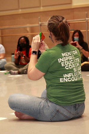 Marissa Nesbit sitting on floor teaching students
