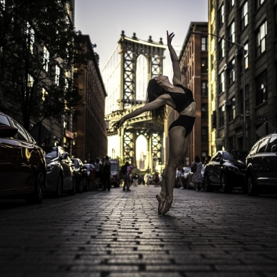 Laura Dearman in a red leotard jumping in NYC Grand Central Station